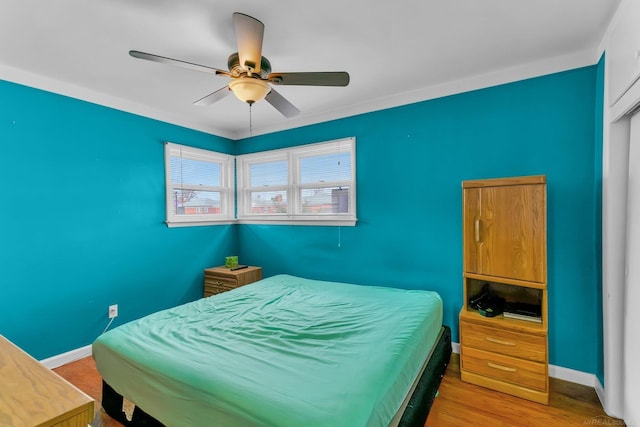 bedroom featuring ceiling fan, wood finished floors, and baseboards