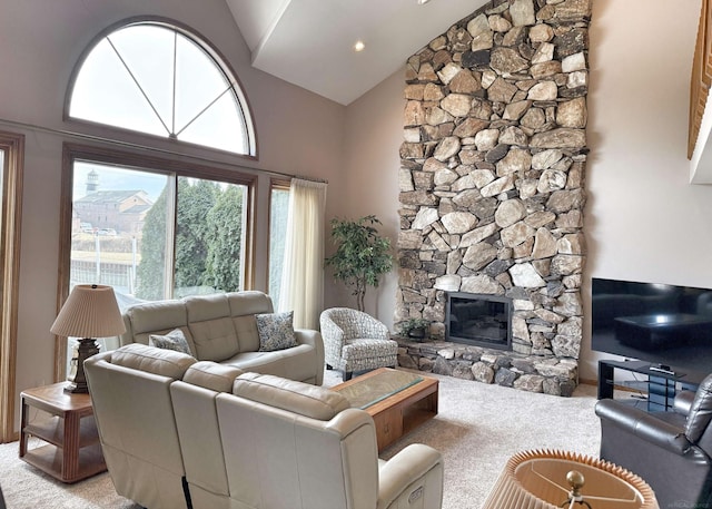 living area with high vaulted ceiling, light colored carpet, and a stone fireplace