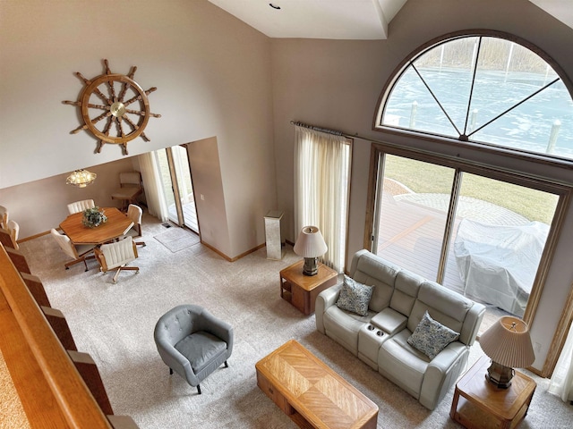 living area with baseboards, high vaulted ceiling, and carpet flooring