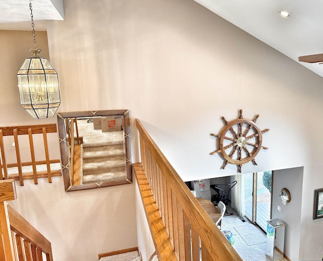 stairs with a high ceiling and a notable chandelier