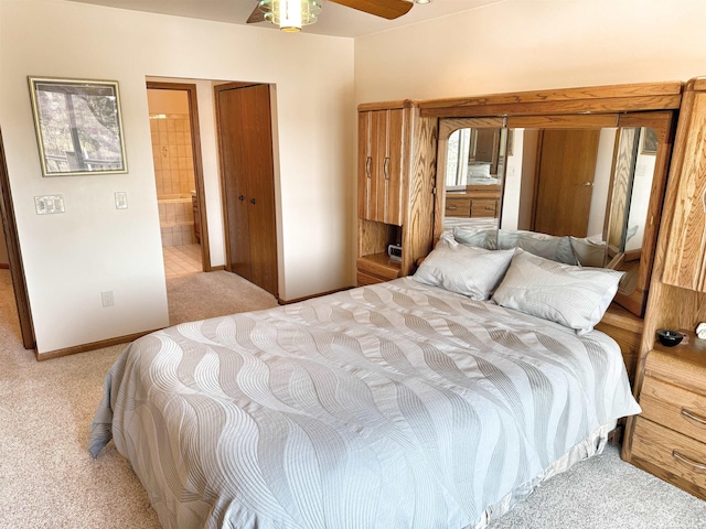 carpeted bedroom featuring ceiling fan, ensuite bath, and baseboards