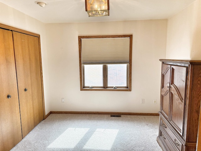 carpeted bedroom with visible vents, baseboards, and a closet