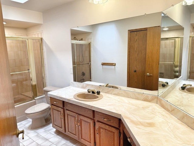 bathroom with toilet, tile patterned flooring, enclosed tub / shower combo, and vanity