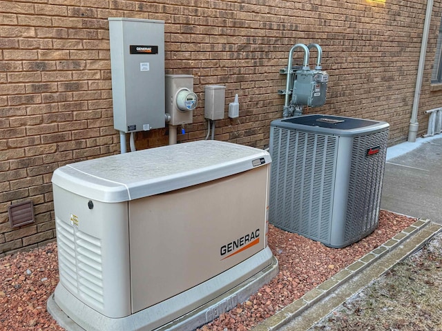 details with brick siding, gas meter, central AC unit, electric meter, and a power unit