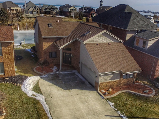 exterior space featuring brick siding, a shingled roof, and a residential view