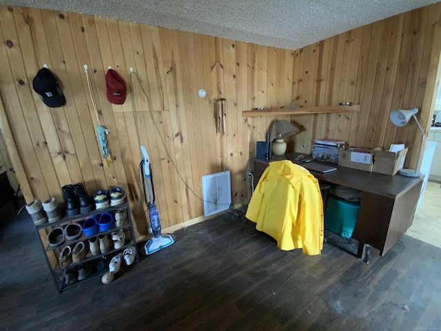 office with wooden walls, a textured ceiling, and wood finished floors