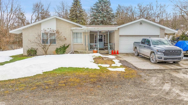 ranch-style home with a garage, brick siding, and driveway