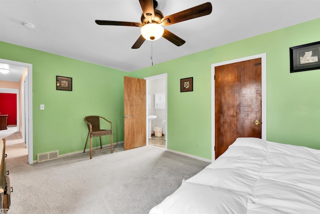 carpeted bedroom with a ceiling fan, visible vents, connected bathroom, and baseboards