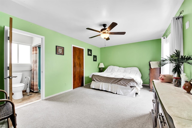 bedroom with carpet floors, ceiling fan, ensuite bath, and baseboards