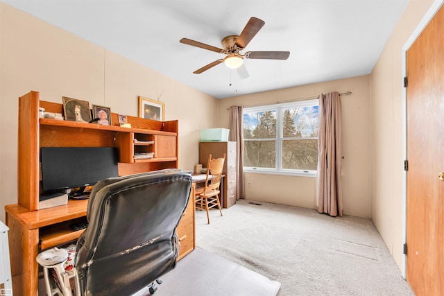 carpeted home office featuring a ceiling fan