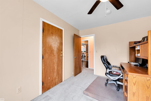 carpeted home office with a ceiling fan