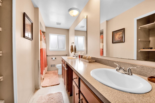 full bathroom featuring visible vents, a sink, toilet, and double vanity