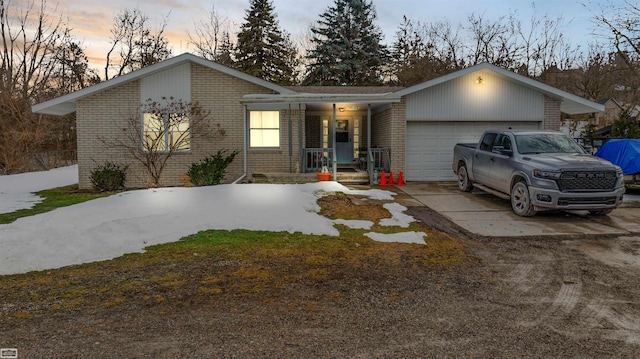 view of front facade featuring driveway, a garage, and brick siding