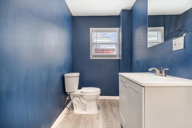 bathroom featuring baseboards, vanity, toilet, and wood finished floors