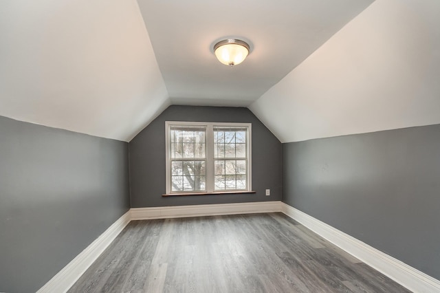 bonus room featuring lofted ceiling, baseboards, and wood finished floors