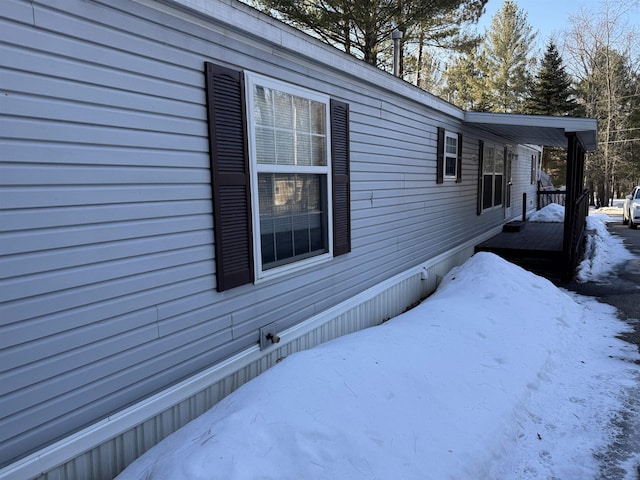 view of snow covered exterior with a deck