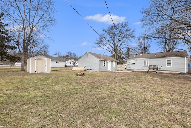 view of yard with a storage shed, an outdoor fire pit, an outdoor structure, and fence