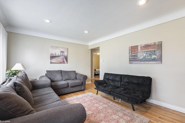 living area with recessed lighting, baseboards, and light wood finished floors