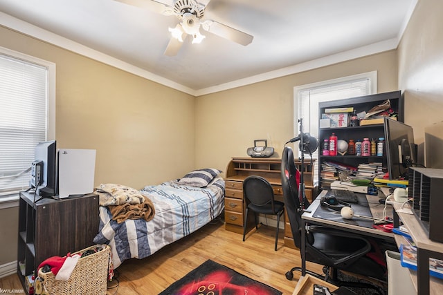 bedroom featuring ornamental molding, ceiling fan, and wood finished floors