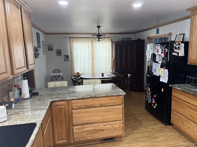 kitchen with a peninsula, light wood-type flooring, black fridge with ice dispenser, and crown molding