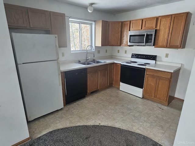 kitchen featuring white appliances, a sink, light countertops, brown cabinets, and light floors