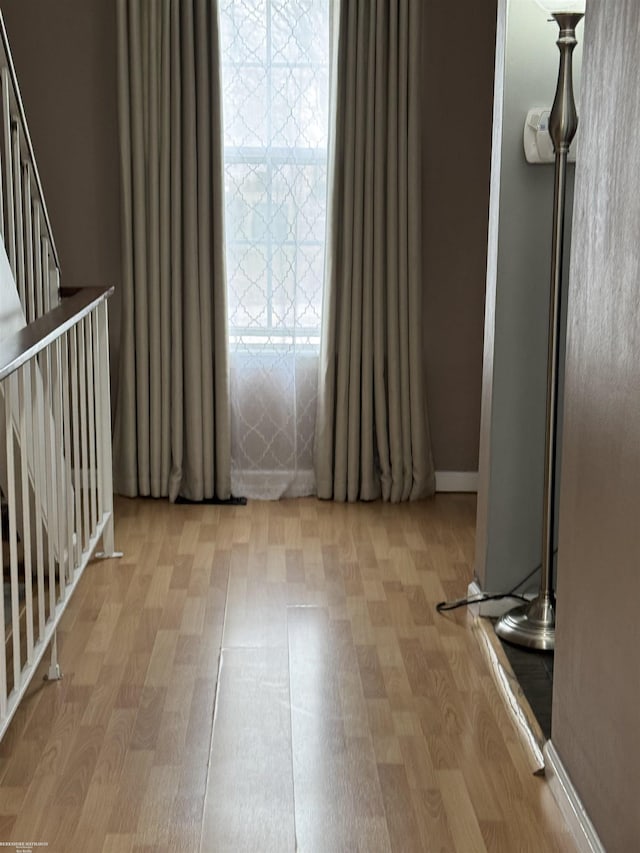 empty room featuring stairway and wood finished floors