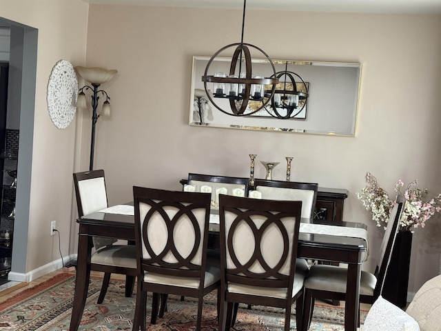 dining space featuring baseboards and an inviting chandelier