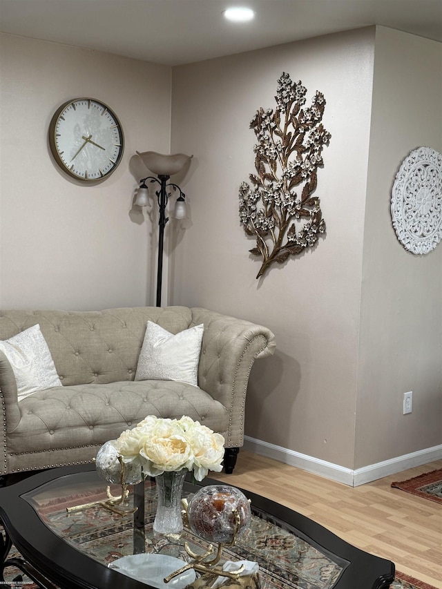 living area with baseboards and wood finished floors