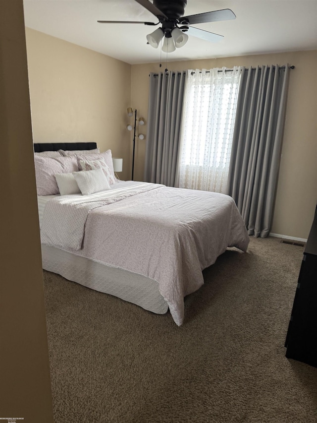 carpeted bedroom featuring a ceiling fan and baseboards