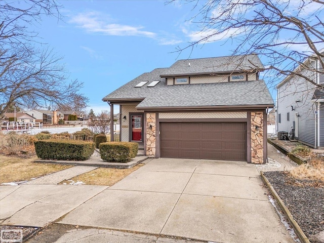 traditional home featuring an attached garage, stone siding, concrete driveway, and roof with shingles