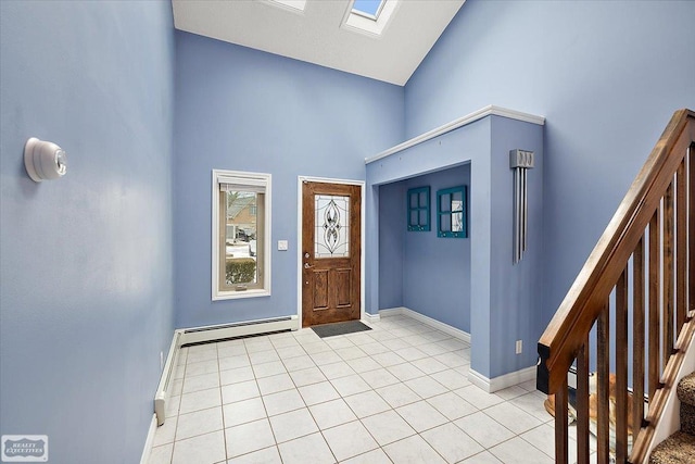 entryway featuring a skylight, stairway, baseboard heating, light tile patterned flooring, and high vaulted ceiling