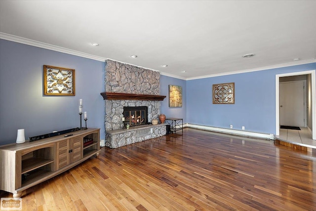 living area with ornamental molding, baseboard heating, and wood finished floors