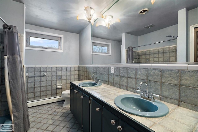 bathroom featuring a baseboard radiator, visible vents, and a sink