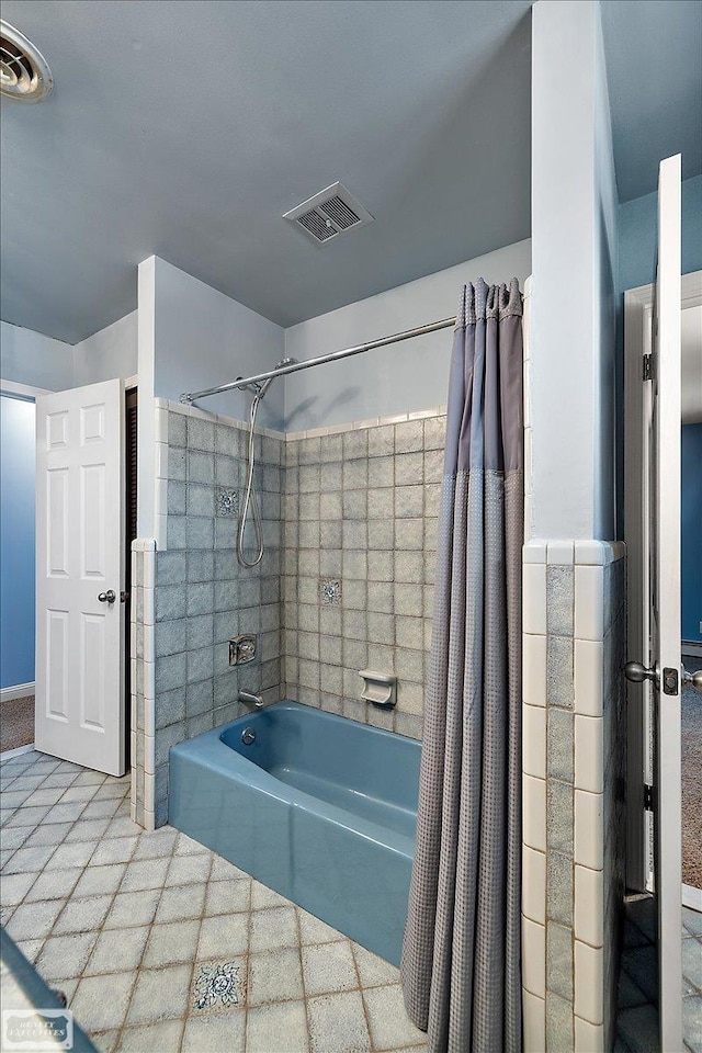 bathroom featuring visible vents and shower / tub combo with curtain