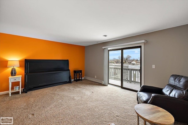 living area featuring a baseboard heating unit, carpet floors, and baseboards