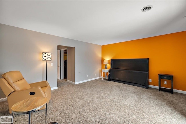 living area with visible vents, baseboards, and carpet flooring