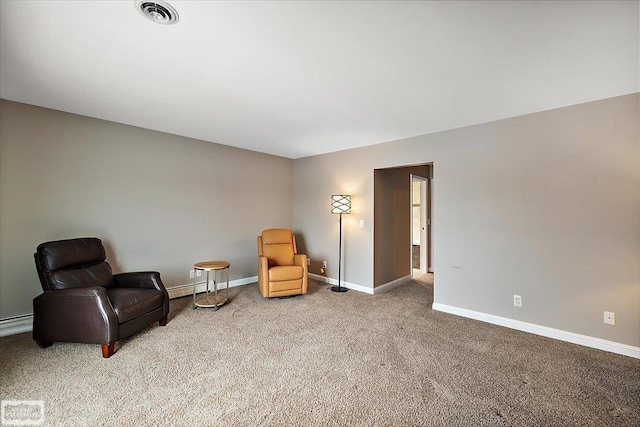 sitting room featuring a baseboard heating unit, baseboards, visible vents, and carpet flooring