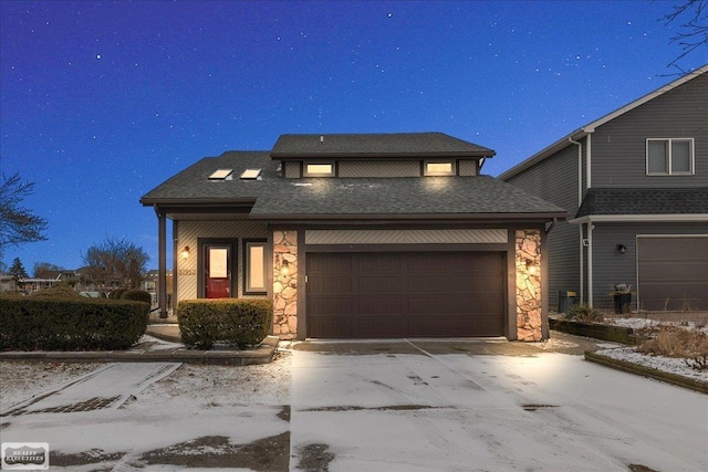 view of front of home featuring stone siding, roof with shingles, driveway, and an attached garage