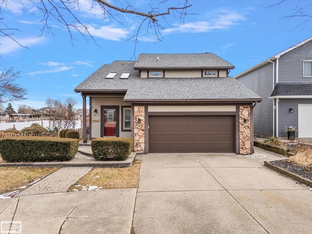 view of front of property featuring a garage, stone siding, a shingled roof, and concrete driveway