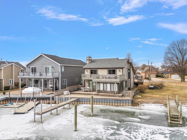 snow covered property featuring a chimney and a balcony