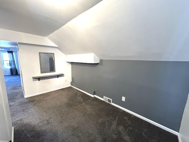 bonus room featuring visible vents, baseboards, lofted ceiling, and dark carpet