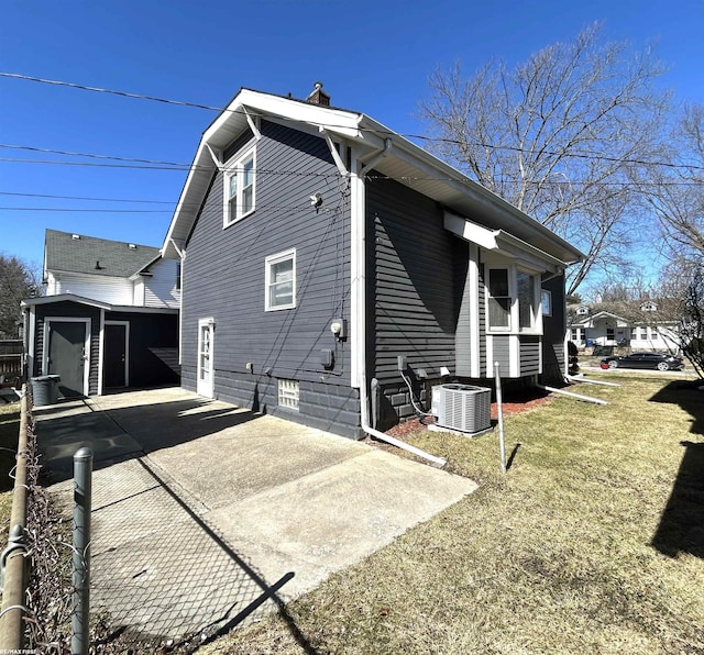 view of property exterior featuring cooling unit, an outdoor structure, and concrete driveway