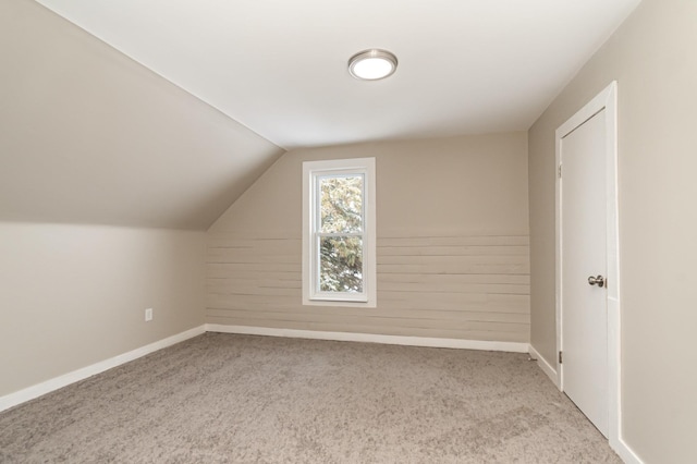 bonus room with baseboards, vaulted ceiling, and carpet flooring