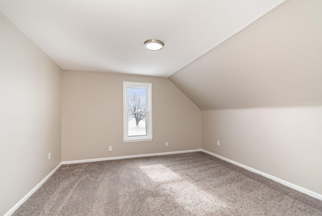 bonus room featuring lofted ceiling, carpet floors, and baseboards