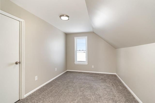 additional living space with baseboards, vaulted ceiling, and carpet flooring