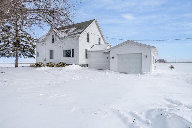 snow covered property featuring a garage