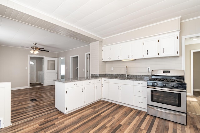 kitchen featuring dark wood-style floors, white cabinetry, a sink, a peninsula, and stainless steel gas range oven