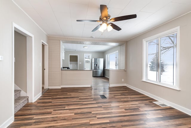 unfurnished living room featuring dark wood-style floors, visible vents, and baseboards