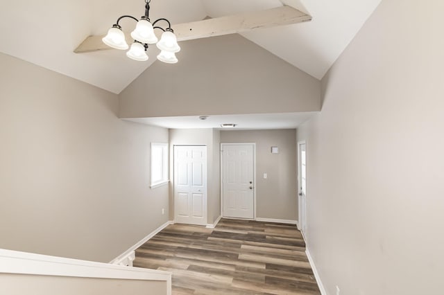 foyer with a notable chandelier, high vaulted ceiling, wood finished floors, and baseboards