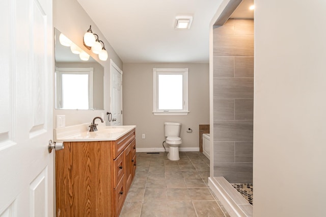 full bathroom featuring baseboards, toilet, tile patterned flooring, a tile shower, and vanity